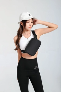 Detail shot of a black nylon waterproof crossbody waist bag worn with sports apparel