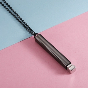 Macro shot of black titanium steel bar pendant necklace with silver cube accent