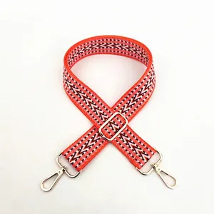 Ethnic style woven cotton bag strap with orange geometric patterns and gold metal buckles