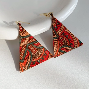 Close-up of geometric triangle earrings with colorful retro ethnic mandala pattern print