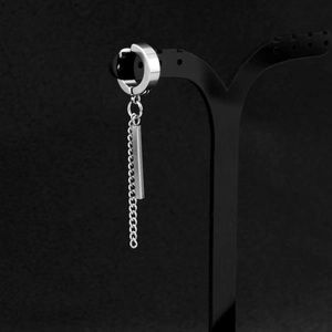 Macro view of silver titanium steel hoop earring with long chain and rectangular pendant