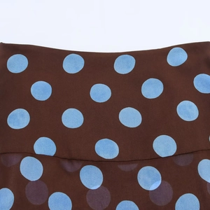 Close-up of brown chiffon fabric with light blue polka dots and delicate seam detail