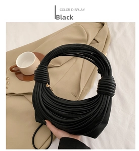 Detail of black PU leather hobo bag with unique knotted handle and gold zipper