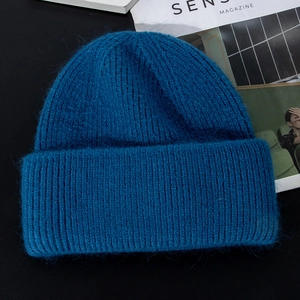 Close-up of deep blue fuzzy knit beanie showing thick long rabbit fur texture and soft weave