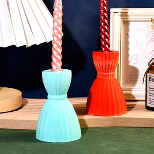 Detail of hourglass striped candle holder with elegant pleated texture and spiral candles