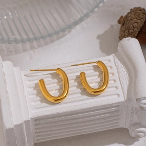 Minimalist 18K gold-plated U-shaped stud earrings on a classic white pedestal stand