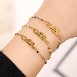 Golden stainless steel bracelets with colorful beads and crown charms worn on wrist