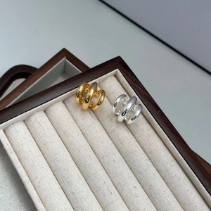 Minimalist multi-layer gold and silver ear cuffs on a professional jewelry display tray