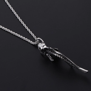 Detailed view of silver shark fishbone pendant on a twisted chain over black background