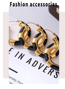 Macro view of gold plated hoop earrings with black enamel leopard print pattern