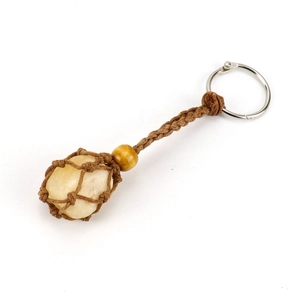 Detail of hand-woven brown cord mesh bag holding raw yellow crystal with a wood bead