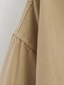 Close-up of khaki canvas jacket showing detailed stitching and heavy cotton fabric texture