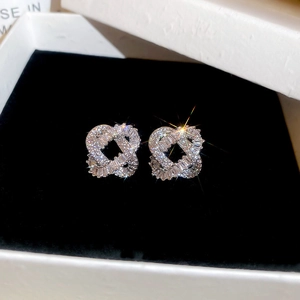 Macro shot of silver interlocking heart earrings with sparkling cubic zirconia on black velvet
