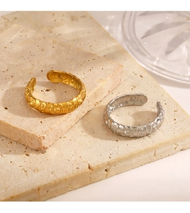 Macro shot of gold and silver steel rings with embossed flower patterns on stone