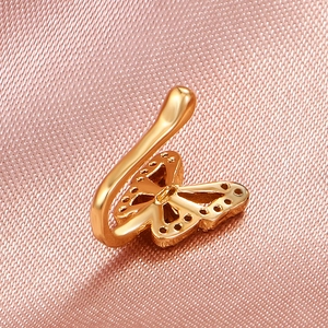 Minimalist gold U-shaped butterfly nose clip with hollow design on pink background