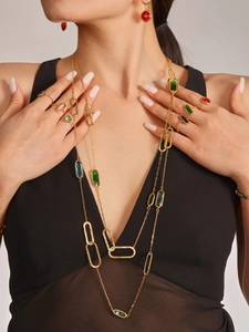 Detailed close-up of gold necklace with colorful rectangle glass stones on a model