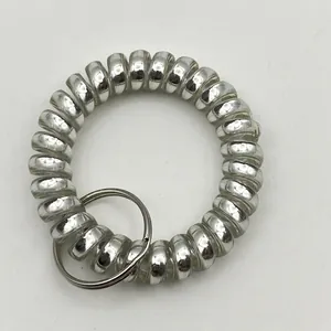 Silver metallic matte spiral wristlet with steel key ring on grey textured surface