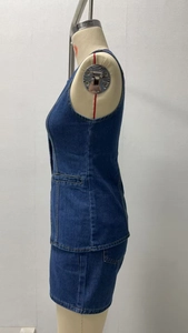 Dettaglio del set in denim blu scuro con cuciture gialle a contrasto e tasche laterali