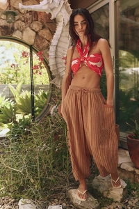 Detailed close-up of brown striped harem pants with elastic waist and large side pockets