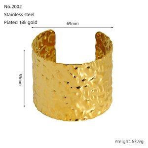 Detailed view of wide 18K gold-plated stainless steel cuff with hammered texture finish