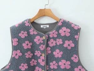 Close-up of grey fleece vest featuring pink floral patterns and wooden button detail