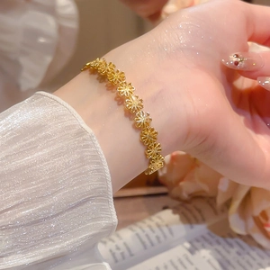 Detail of elegant gold镂空flower cuff bracelet worn on wrist with floral background