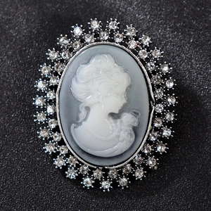 Macro detail of oval vintage cameo brooch with rhinestone inlay and Victorian relief
