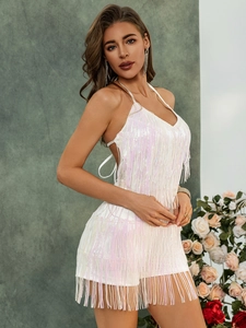 Close-up of white sequined dress with tassel details and shiny fringe for summer