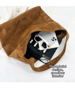 Macro shot showing the spacious interior of this large brown suede tote bag with daily items