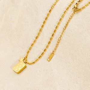 Detail of gold checkered pendant with star charm and K18 hallmark on bead chain