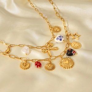 Detail of gold charms including sun, star, heart, bow, and pearls on silk fabric