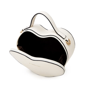 Close-up of heart-shaped cream handbag showing interior lining and gold hardware
