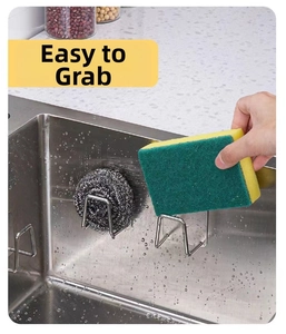 Detail of stainless steel sponge holder mounted on sink wall for easy kitchen storage