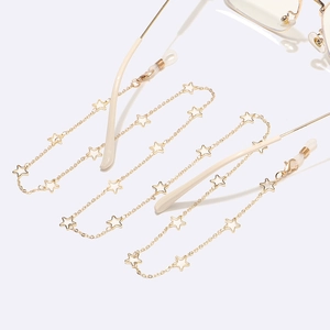 Detail of hollow star shaped metal eyewear chain in light gold with white hook ends