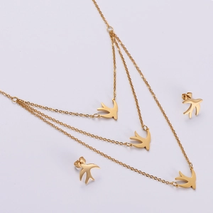 Detailed close-up of a triple-layered gold swallow necklace set with matching stud earrings