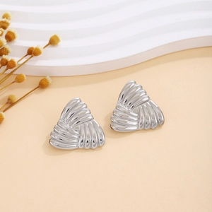 Detailed view of silver textured triangular earrings with radial ribbed metallic finish