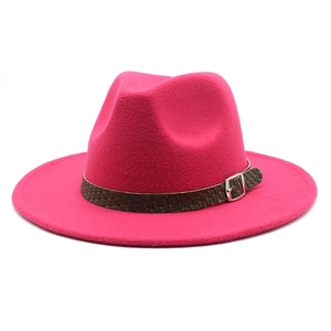 Dettaglio di un cappello fedora in lana rosa con fascia intrecciata e fibbia in metallo