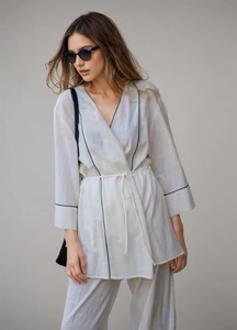 Détail d'un ensemble kimono à col en V avec liseré contrasté et pantalon en lin