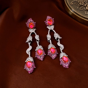 Close-up of elegant silver drop earrings with pink oval gems and sparkling rhinestones
