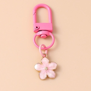 Detailed view of pink enamel cherry blossom pendant with golden metal lobster clasp