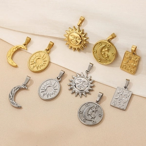 Detailed close-up of 18K gold and silver celestial pendants with moon and sun motifs
