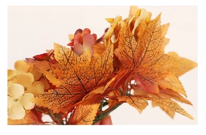 Detailed view of autumn candle ring with realistic maple leaves and fabric flowers