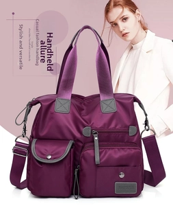 Detail view of purple nylon handbag featuring multiple functional pockets and durable straps