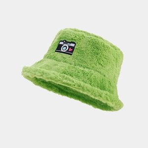 Detail of green fuzzy bucket hat featuring a camera and heart embroidery patch