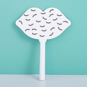 Detailed view of white lip-shaped handheld mirror featuring creative eyelash pattern design