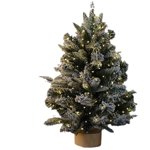 Mini DIY Christmas tree with snowy needles, warm LED lights, and a sturdy wooden base