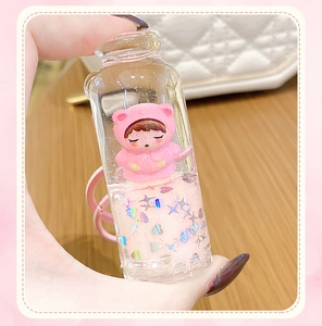 Detail of pink liquid glitter keychain featuring a cute bear figurine and star sequins