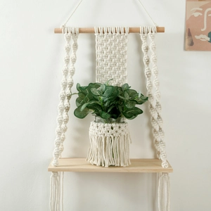 Detail of bohemian handmade cotton rope macrame weave and wooden shelf with tassels