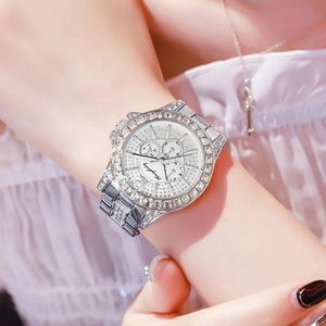 Luxury women's quartz watch with sparkling rhinestones and silver steel strap on wrist
