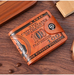 Macro shot of retro brown leather wallet with embossed US dollar pattern on wood surface